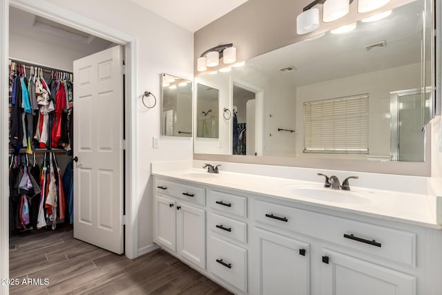 3444 E Flamingo Ct, Gilbert, AZ 85297 - bathroom with double vanity, a walk in closet, wood finished floors, and a shower stall