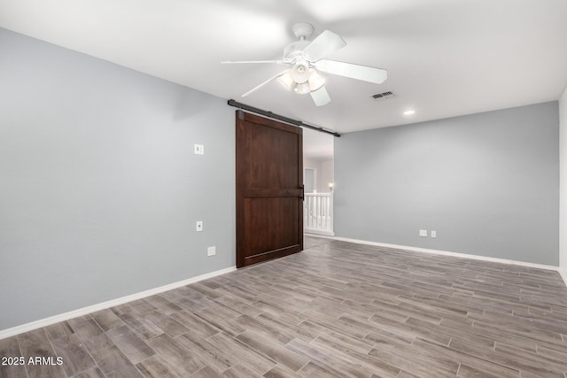 3444 E Flamingo Ct, Gilbert, AZ 85297 - empty room featuring a barn door, wood finished floors, ceiling fan, and recessed lighting
