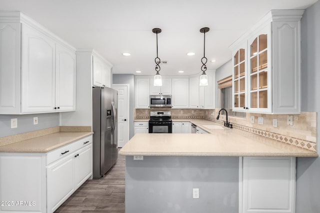3444 E Flamingo Ct, Gilbert, AZ 85297 - kitchen featuring appliances with stainless steel finishes, a peninsula, glass insert cabinets, wood finished floors, and tasteful backsplash