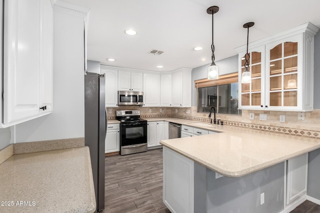 3444 E Flamingo Ct, Gilbert, AZ 85297 - kitchen featuring appliances with stainless steel finishes, a peninsula, white cabinetry, glass insert cabinets, and decorative backsplash