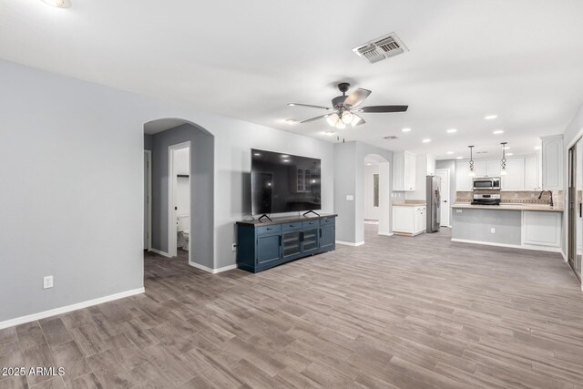 3444 E Flamingo Ct, Gilbert, AZ 85297 - unfurnished living room featuring arched walkways, a ceiling fan, light wood finished floors, and recessed lighting