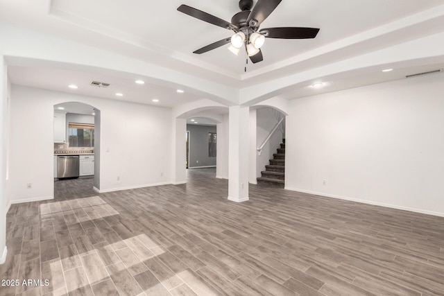 3444 E Flamingo Ct, Gilbert, AZ 85297 - unfurnished living room with arched walkways, recessed lighting, ceiling fan, a raised ceiling, and stairway
