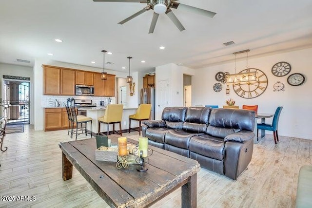 living room featuring light wood-type flooring and ceiling fan