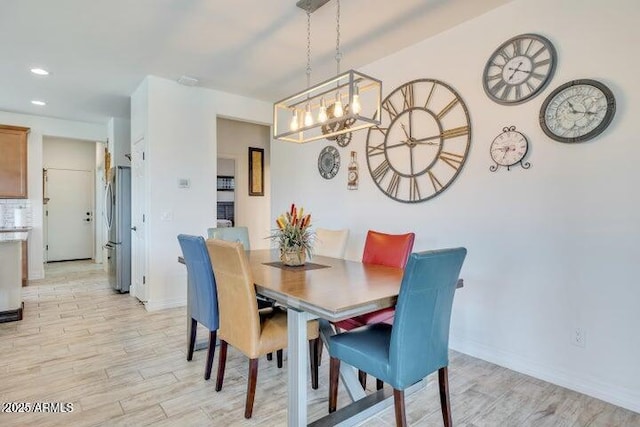 dining area with an inviting chandelier and light hardwood / wood-style floors