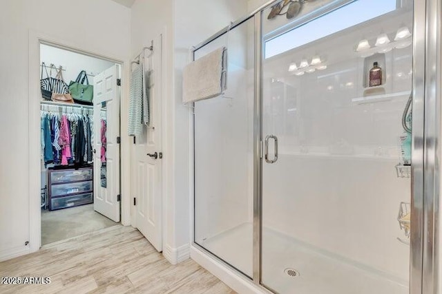 bathroom featuring wood-type flooring and an enclosed shower