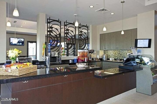 kitchen featuring decorative backsplash, light tile patterned floors, and dark brown cabinetry