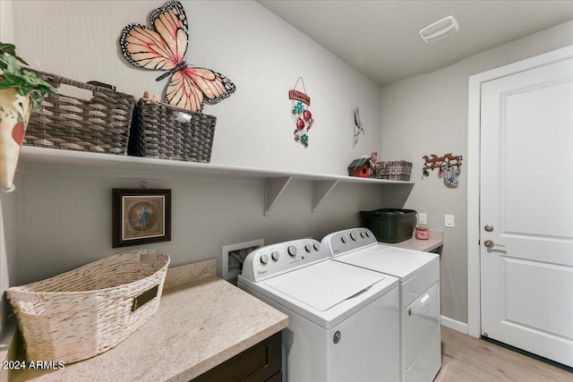 laundry room with light hardwood / wood-style flooring and washer and dryer