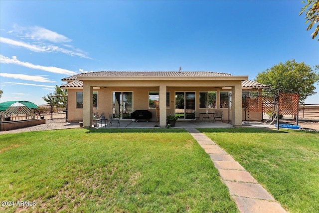 rear view of property featuring a patio and a yard