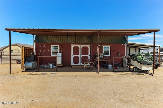 rear view of house featuring an outdoor structure