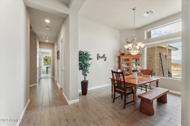 dining space featuring an inviting chandelier, light wood-type flooring, and plenty of natural light