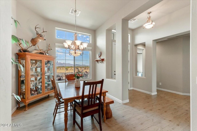 dining room featuring light wood-type flooring and a notable chandelier