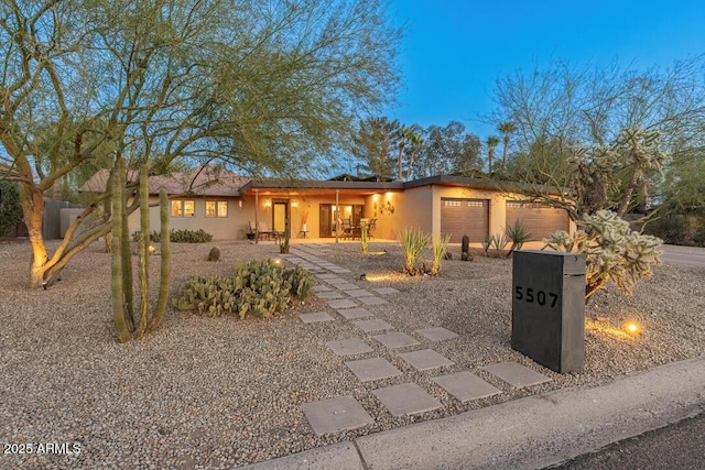 view of front of home with a garage and stucco siding