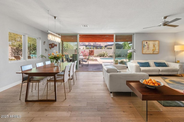 dining room featuring a healthy amount of sunlight, visible vents, hardwood / wood-style floors, and a textured ceiling