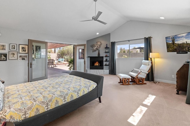 carpeted bedroom with vaulted ceiling, multiple windows, a warm lit fireplace, and access to exterior