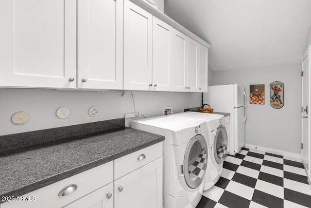 clothes washing area with cabinet space, dark floors, baseboards, and separate washer and dryer