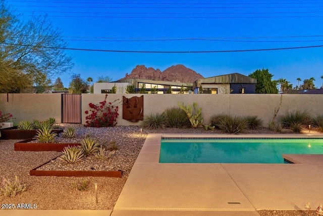 view of swimming pool featuring a fenced in pool, fence private yard, and a mountain view