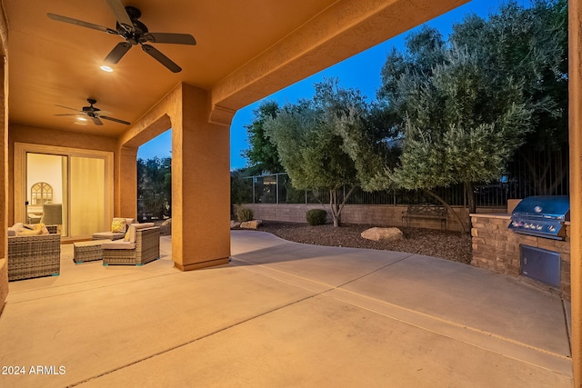 patio terrace at dusk with an outdoor living space, grilling area, an outdoor kitchen, and ceiling fan