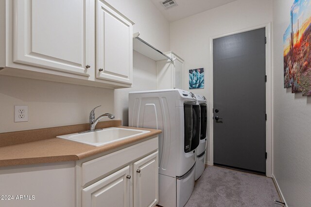 washroom with cabinets, light colored carpet, sink, and independent washer and dryer