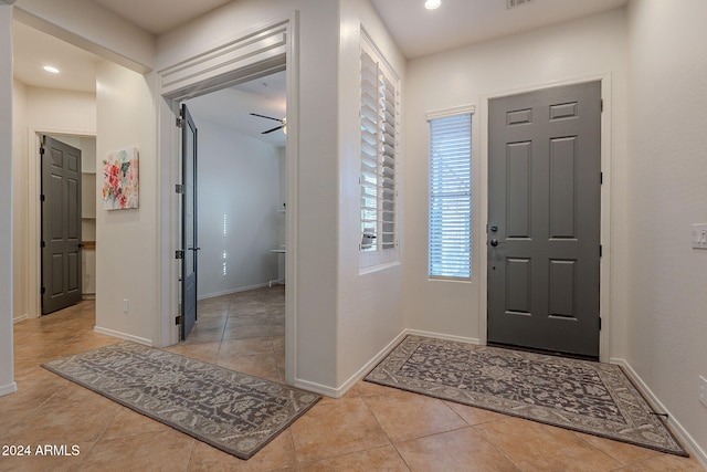 entryway featuring light tile patterned floors and ceiling fan