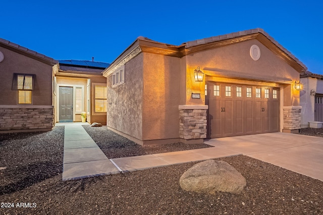 view of front of property with a garage and solar panels