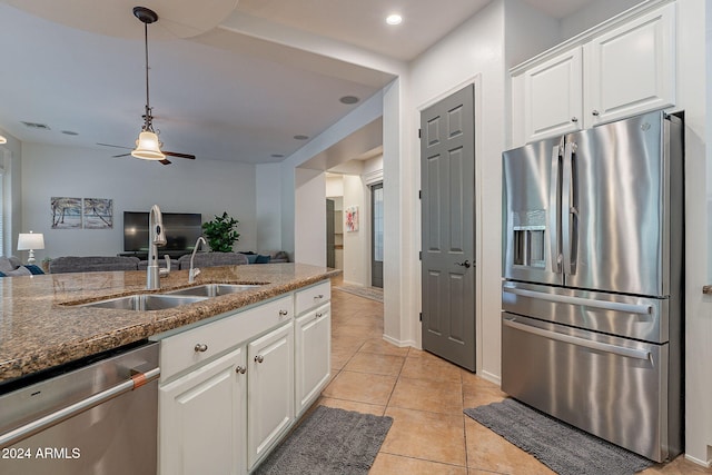 kitchen featuring dark stone counters, appliances with stainless steel finishes, sink, and white cabinets