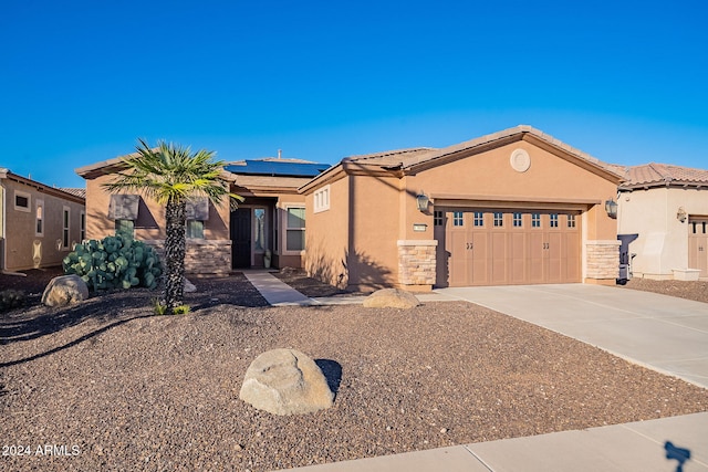 view of front of property with a garage and solar panels