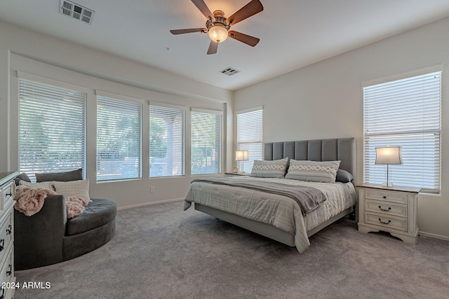 bedroom with light carpet, multiple windows, and ceiling fan