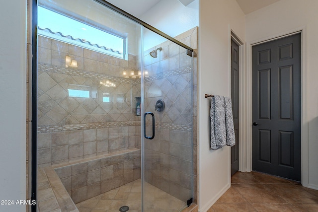 bathroom featuring a shower with door and tile patterned flooring