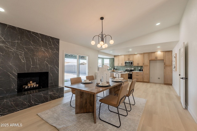 1609 W Yukon Dr, Phoenix, AZ 85027 - dining area featuring light wood-type flooring, a fireplace, lofted ceiling, recessed lighting, and a chandelier