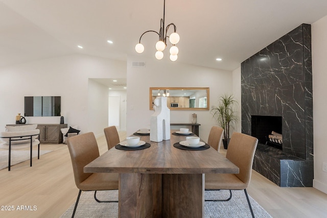 1609 W Yukon Dr, Phoenix, AZ 85027 - dining area featuring vaulted ceiling, light wood-style flooring, recessed lighting, a fireplace, and a chandelier