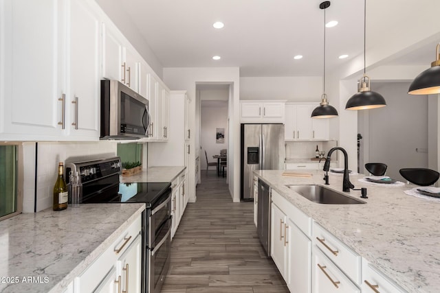 kitchen featuring sink, decorative light fixtures, white cabinets, and appliances with stainless steel finishes