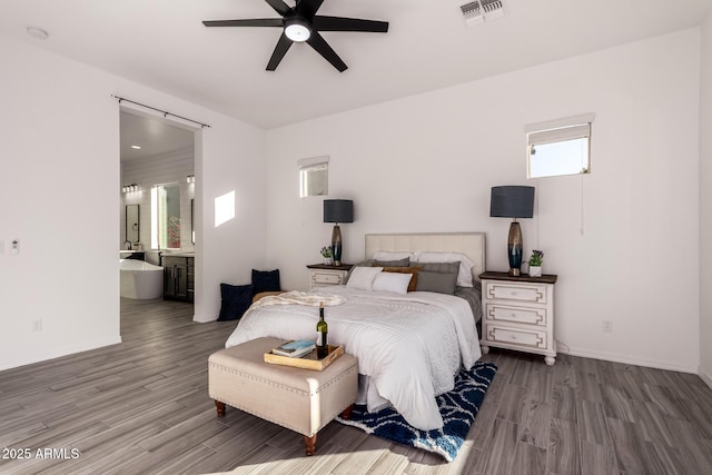 bedroom with hardwood / wood-style flooring, ceiling fan, and connected bathroom