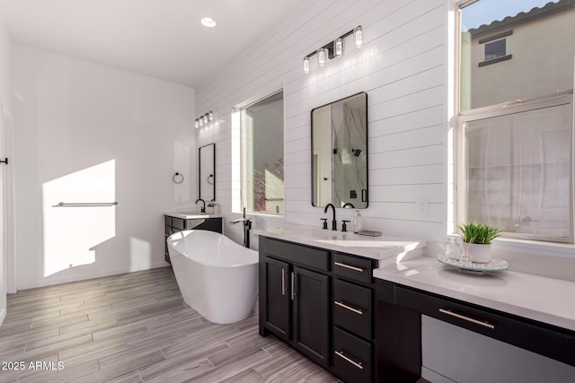 bathroom with vanity and a washtub