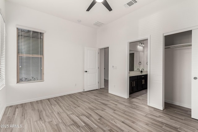 unfurnished bedroom featuring light hardwood / wood-style floors, a closet, ceiling fan, and ensuite bathroom