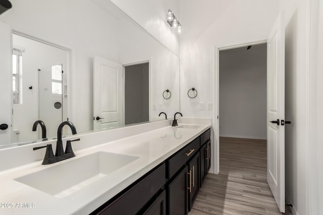 bathroom with vanity, hardwood / wood-style flooring, and vaulted ceiling