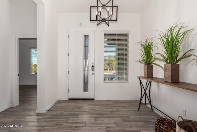 entryway with dark hardwood / wood-style flooring and a chandelier