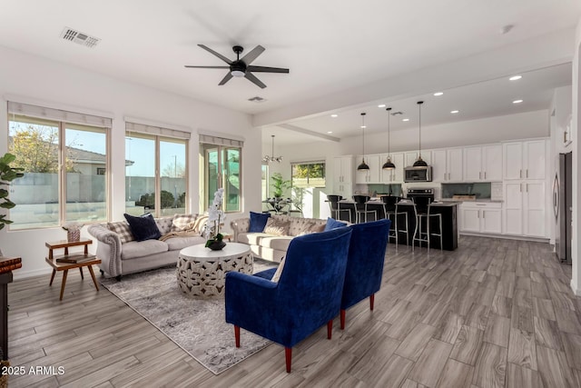 living room featuring ceiling fan with notable chandelier