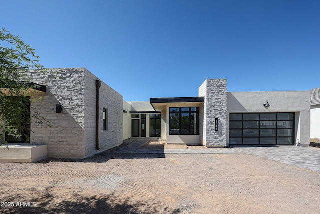 1538 W Wagon Wheel Dr, Phoenix, AZ 85021 - view of front facade with an attached garage, decorative driveway, stucco siding, and stone siding
