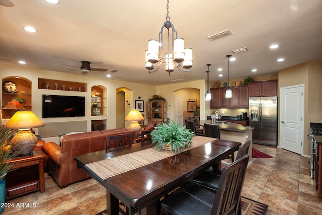 dining room featuring built in features, ceiling fan with notable chandelier, and sink