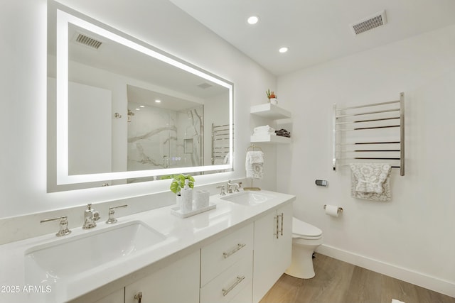 bathroom featuring hardwood / wood-style floors, radiator heating unit, vanity, walk in shower, and toilet