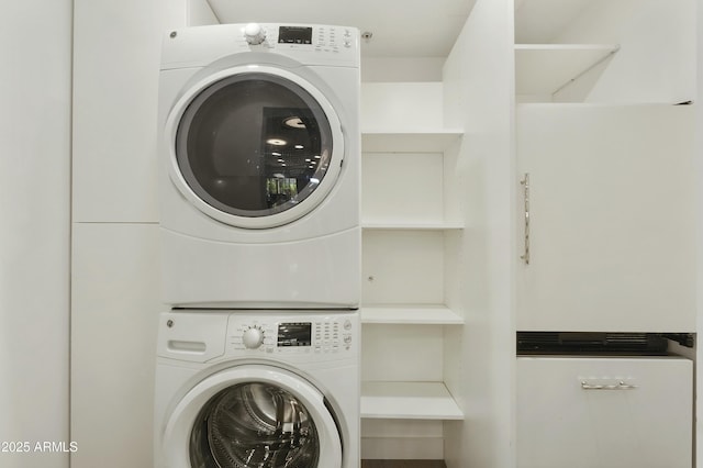 laundry room featuring stacked washer / drying machine