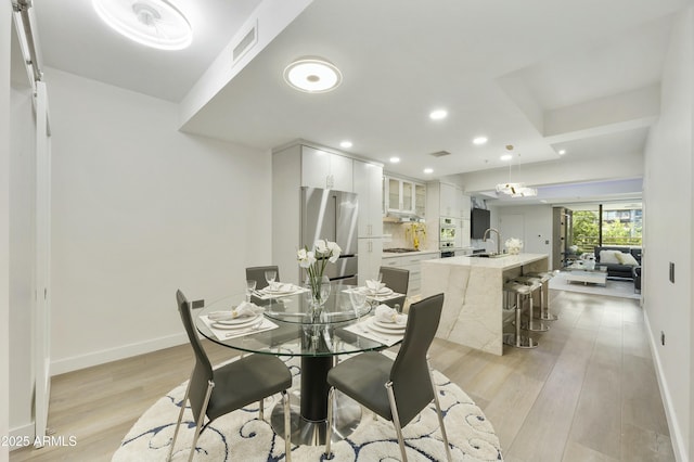 dining room featuring sink and light wood-type flooring