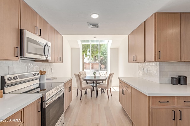 6439 E Redmont Dr, Mesa, AZ 85215 - kitchen featuring stainless steel appliances, light wood-style flooring, light countertops, tasteful backsplash, and recessed lighting