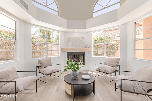 6439 E Redmont Dr, Mesa, AZ 85215 - sitting room with wood finished floors, healthy amount of natural light, a glass covered fireplace, and a high ceiling