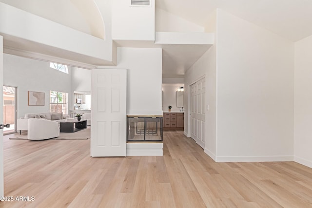 6439 E Redmont Dr, Mesa, AZ 85215 - unfurnished living room featuring a high ceiling and light wood-style flooring