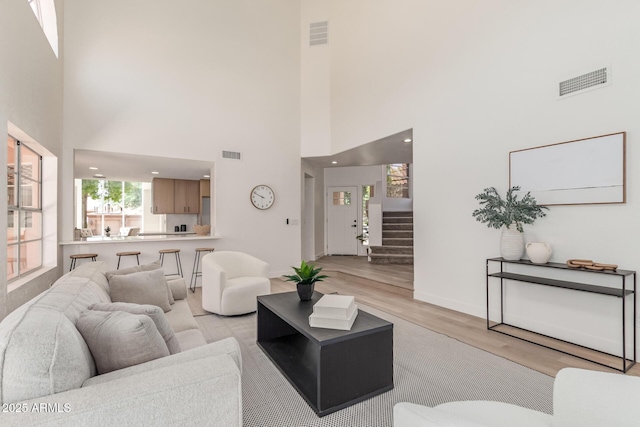 6439 E Redmont Dr, Mesa, AZ 85215 - living area with light wood finished floors, a towering ceiling, and stairway