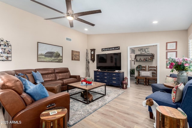 living room featuring vaulted ceiling, light hardwood / wood-style floors, and ceiling fan