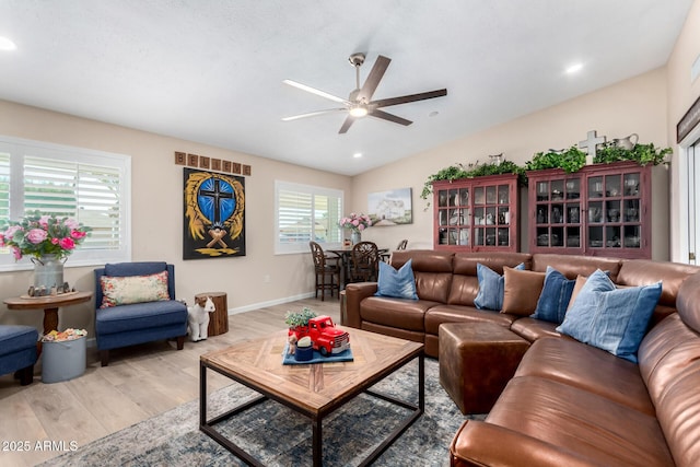 living room featuring vaulted ceiling, ceiling fan, and light wood-type flooring