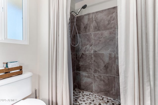 bathroom with a shower with curtain and toilet