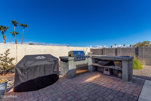 view of patio / terrace featuring an outdoor kitchen and a grill